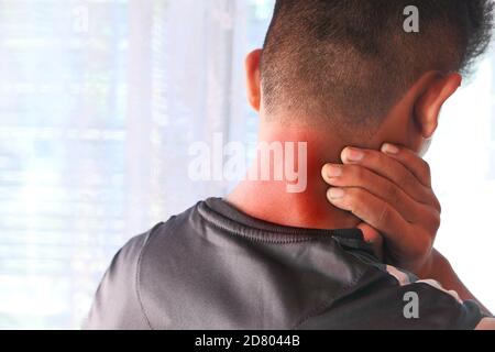 man suffering from neck pain at home. Stock Photo