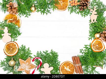Frame made with fir tree branches, oranges, gingerbread cookies Stock Photo