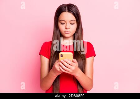 Photo of lovely sweet small lady long hairstyle arms hold telephone texting chatting share post read news surf internet calm look screen wear red t Stock Photo