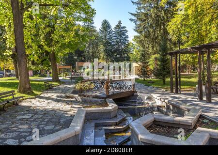 Razlog, Bulgaria - October 20, 2020: Downtown street panoramic view with cafe, autumn trees and fountains Stock Photo