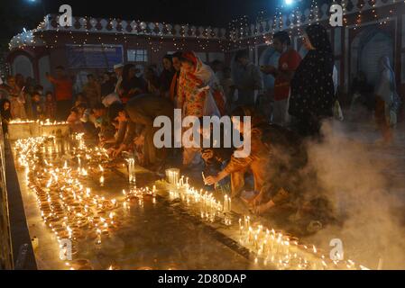 Lahore, Pakistan. 25th Oct, 2020. Pakistani Muslim devotees light candles and earthen lamps at the shrine of famous fifteenth century Sufi Saint Hazrat Mir Mohammed Muayyinul during 397th URS celebrations in Lahore, Pakistan on October 25, 2020. Thousands of people across the country visit the shrine to pay tribute to him during a three-day festival. (Photo by Rana Sajid Hussain/Pacific Press/Sipa USA) Credit: Sipa USA/Alamy Live News Stock Photo