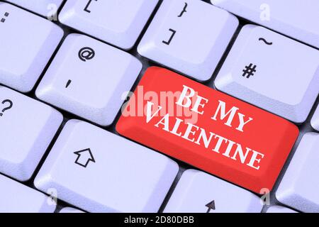 A keyboard with Be My Valentine written in white lettering on a red enter key. Love concept romance internet dating. England, UK Stock Photo