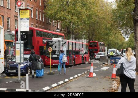 London, UK. 26th Oct, 2020. Cycle lane narrows Chiswick High Road. Cycle Super Highway 9 installation removes the bus lane and causes disruption as bus stops are closed, relocated and positioned between the vehicular traffic and the cycle lane. Credit: Peter Hogan/Alamy Live News Stock Photo