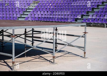 Stadium seats background. Rows of blue plastic empty chairs and rusty grandstand. Theater, exhibitions, shows, festivals or concerts for audience a su Stock Photo