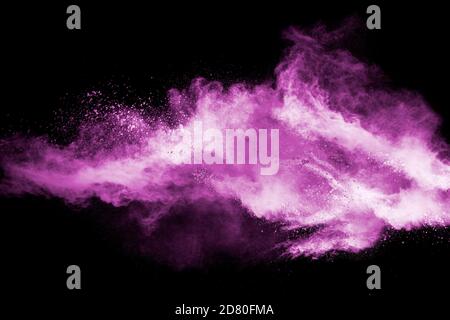 Abstract pink dust particles explosion on black background.Freeze motion of pink powder splash. Stock Photo
