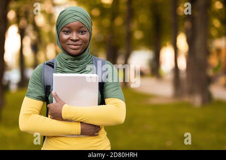 Education For Muslim Women. Black student lady in hijab posing outdoors Stock Photo