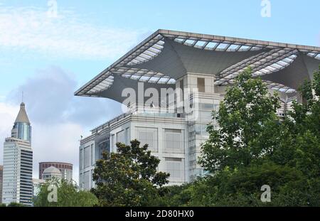 Exterior view of Shanghai Urban Planning Exhibition Center with leafy green trees in foreground Stock Photo