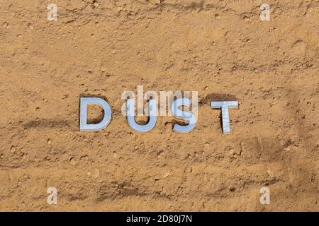 the word dust on dusty road surface in flat lay perspective Stock Photo