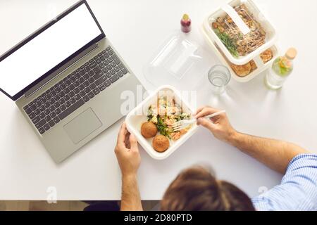 Busy man having lunch break at office desk with laptop computer with blank copy space screen Stock Photo