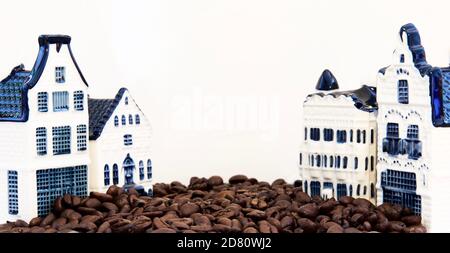 Raw coffee beans in street, scene with houses, cafe. Creative concept, background, white background, copy space, horizontal composition. Stock Photo