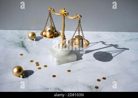 Cost of Christmas holidays concept. Weight scales, vintage balance with stack of coins on marble. Stock Photo