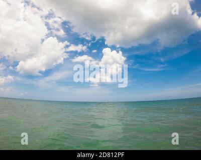 White Puffy Clouds Against A Blue Sky Over the Atlantic Ocean Stock Photo