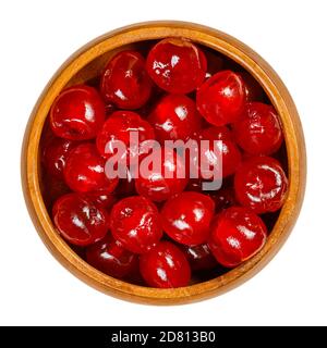 Maraschino cherries in a wooden bowl. Also cocktail cherries, whole red fruits of Prunus avium, preserved and sweetened in sugar syrup. Stock Photo