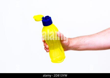 Man's hand holds bottle of water, isolated on white background. Close up. Stock Photo