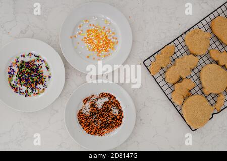 halloween sprinkles and sugar cookies on white quartz counter Stock Photo