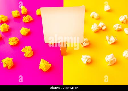 crumpled paper wads with a sheet of white and yellow paper Stock Photo