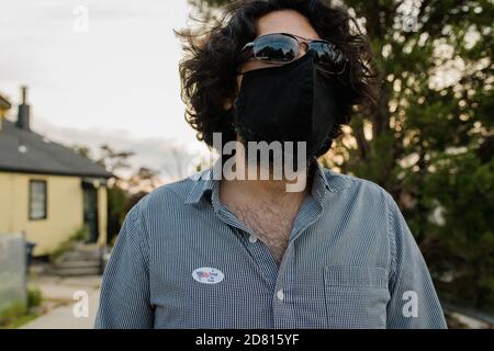 Man wearing protective face mask and I voted by mail sticker Stock Photo