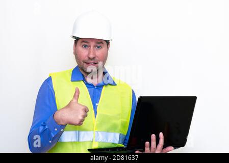 Attractive caucasian Technician Holding Laptop Over White Background.Makes gestures Stock Photo