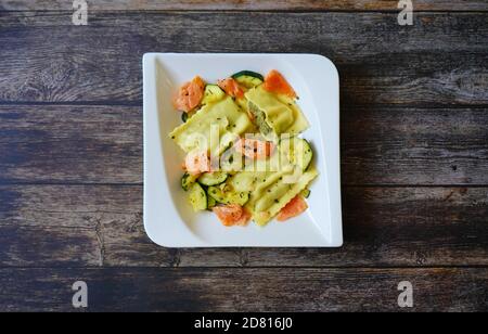 German home cooking: Maultaschen (filled pasta - also called „Swabian ravioli“) with salmon and zucchini. Stock Photo