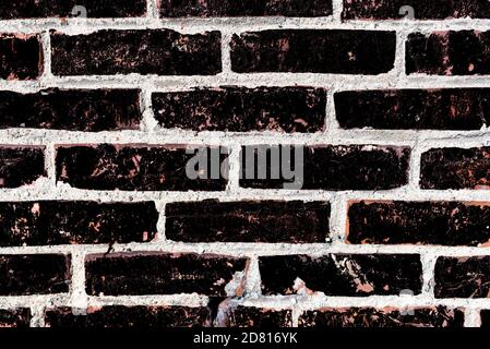 The black brick texture with cracks and scratches can be used as a background Stock Photo