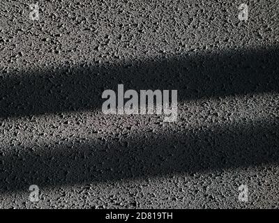 Geometric textured background with copy space. Rough plaster putty wall with grey stained surface and stripes of light and shadow Stock Photo