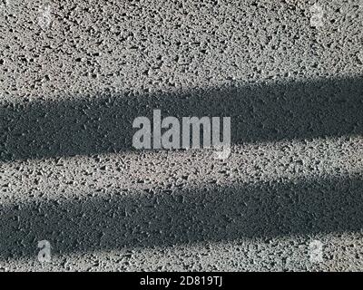 Striped abstract textured background with copy space. Rough plaster wall with grey stained surface and stripes of light and shadow Stock Photo