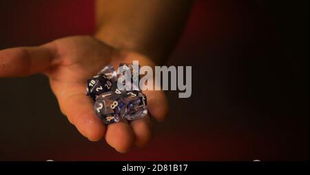 A hand holding a set of dices ready to throw with negative space Stock Photo