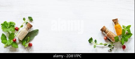 Fresh herbs and spices in small jars on white copy space Stock Photo