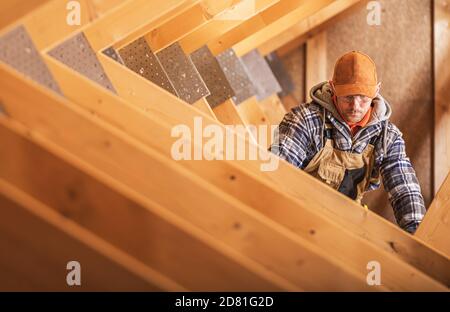 Air Vent Heating and Cooling Distribution Canal Installation by Caucasian Construction Contractor in His 40s. Home Attic Air Shafts. Stock Photo