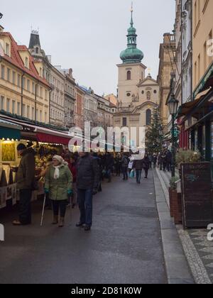 Prague, Czech Republic, December 12, 2019: Tourist people shopping at traditional christmas Market, Havelska trznice street with stalls selling gifts, Stock Photo