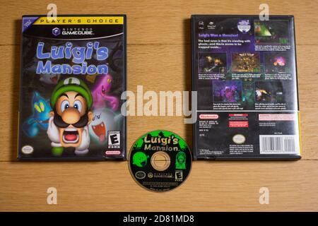 A Disc and Case for Luigi's Mansion for the Nintendo Gamecube on a wood floor. Stock Photo