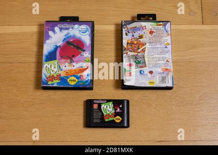 A Cool Spot Cartridge and Front and Back Of It's Game Case for the Sega Genesis on a wood floor. Stock Photo