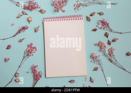 pink flowers flat lay with Blank white notepad Stock Photo