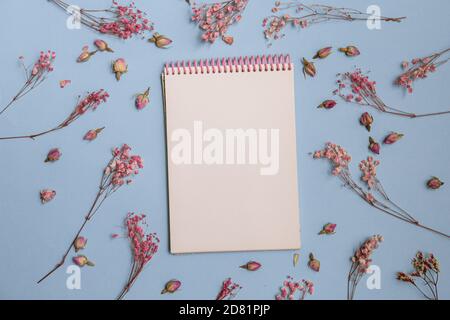 pink flowers flat lay with Blank white notepad Stock Photo