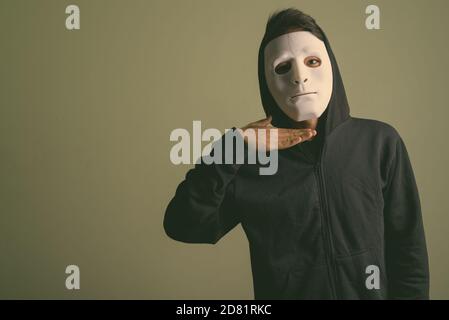 Young handsome Indian man wearing hoodie against colored background Stock Photo