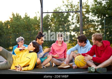 young basketball players take a break after game, have fun and talk. in playground Stock Photo
