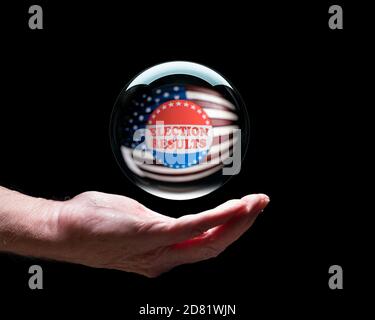 Senior caucasian hand with a floating crystal futures or fortune telling ball with I Voted sticker to predict the Presidential election results Stock Photo