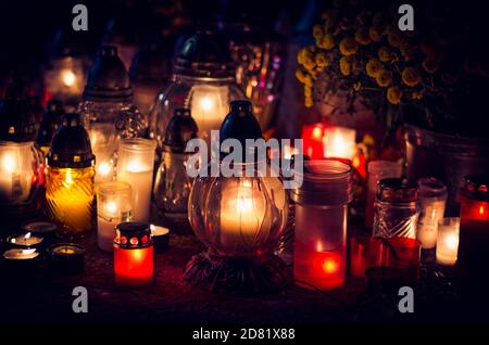 candles burning in lanterns at night during All Saints Day Stock Photo