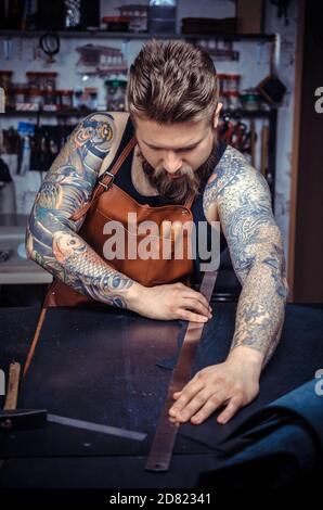 Leather Currier forms new leather product in the workplace Stock Photo