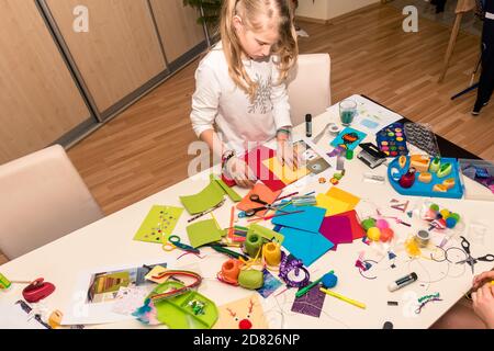 adorable blond girl making christmas card for friends and relatives Stock Photo