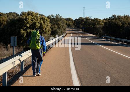 Pilgrim walking on a road during his pilgrimage on Vía de la Plata, in the region of Extremadura (Spain). Stock Photo