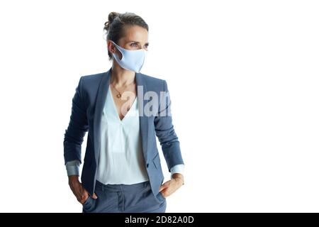Business during coronavirus pandemic. pensive elegant middle aged business woman in a grey suit with medical mask looking into the distance isolated o Stock Photo