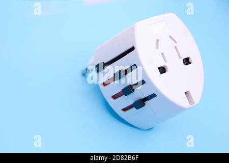 adapter electric adapter multifunctional white on a blue background. Stock Photo