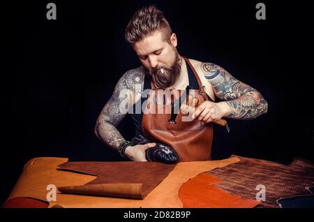 Tanner of leather making quality products at the desk Stock Photo