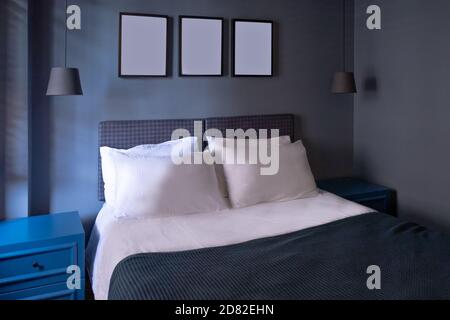 Modern bedroom in luxury apartment in dark blue colors with picture foto frames Stock Photo