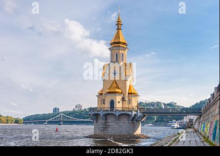Unique temple - Church of St. Nicholas the Wonderworker on the Water, located on the Dnipro River and Pedestrian park bridge.Kyiv, Ukraine Stock Photo