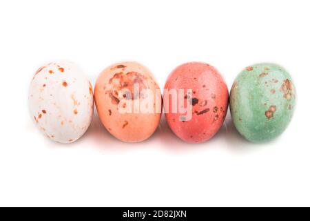 Four chocolate eggs candies isolated on white background. close up, side view, macro. Stock Photo