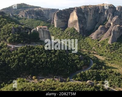 winding road crosses the landscape of the Meteora to go to the Roussanou monastery Stock Photo