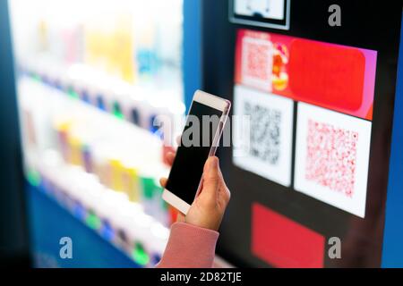 Qr code payment, online shopping, cashless technology concept. women hand hold the smartphone for payment at vendor machine Stock Photo