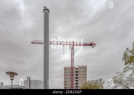 apartment block behind a heating plant chimney with a red construction-crane, Frederikssund, Denmark, October 25, 2020 Stock Photo